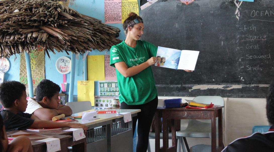 A Projects Abroad volunteer reads a book to a class in Samoa An alternative schoolies volunteer in Samoa reads a book for a class